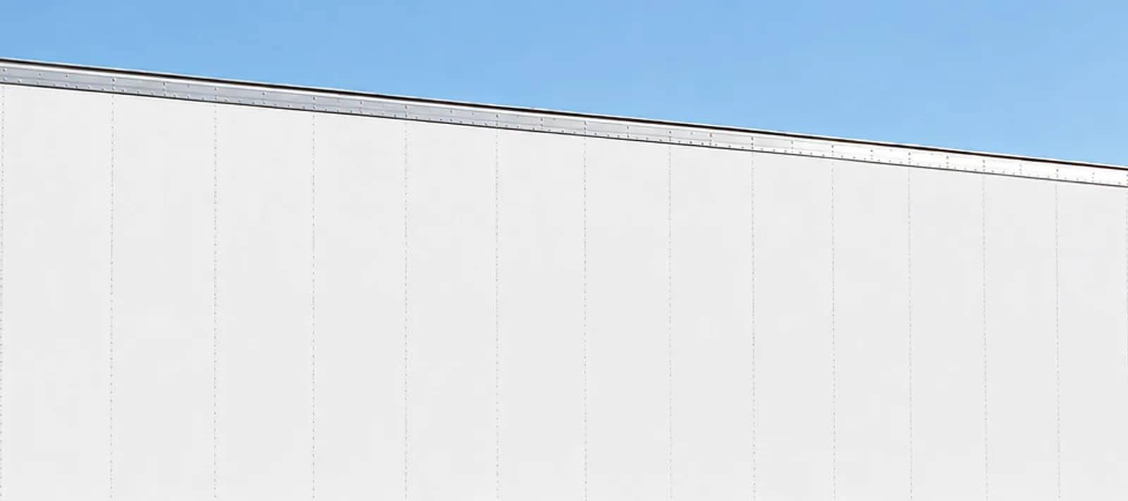 Side panel and top rail of a white 53-foot dry van trailer